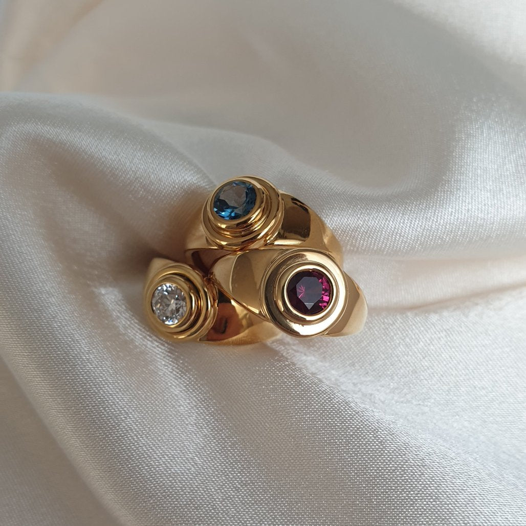 Anillos Ava de oro disponibles con un diamante ético, un granate rodolito o un topacio London. Fabricados artesanalmente por LA MUSA JOYAS